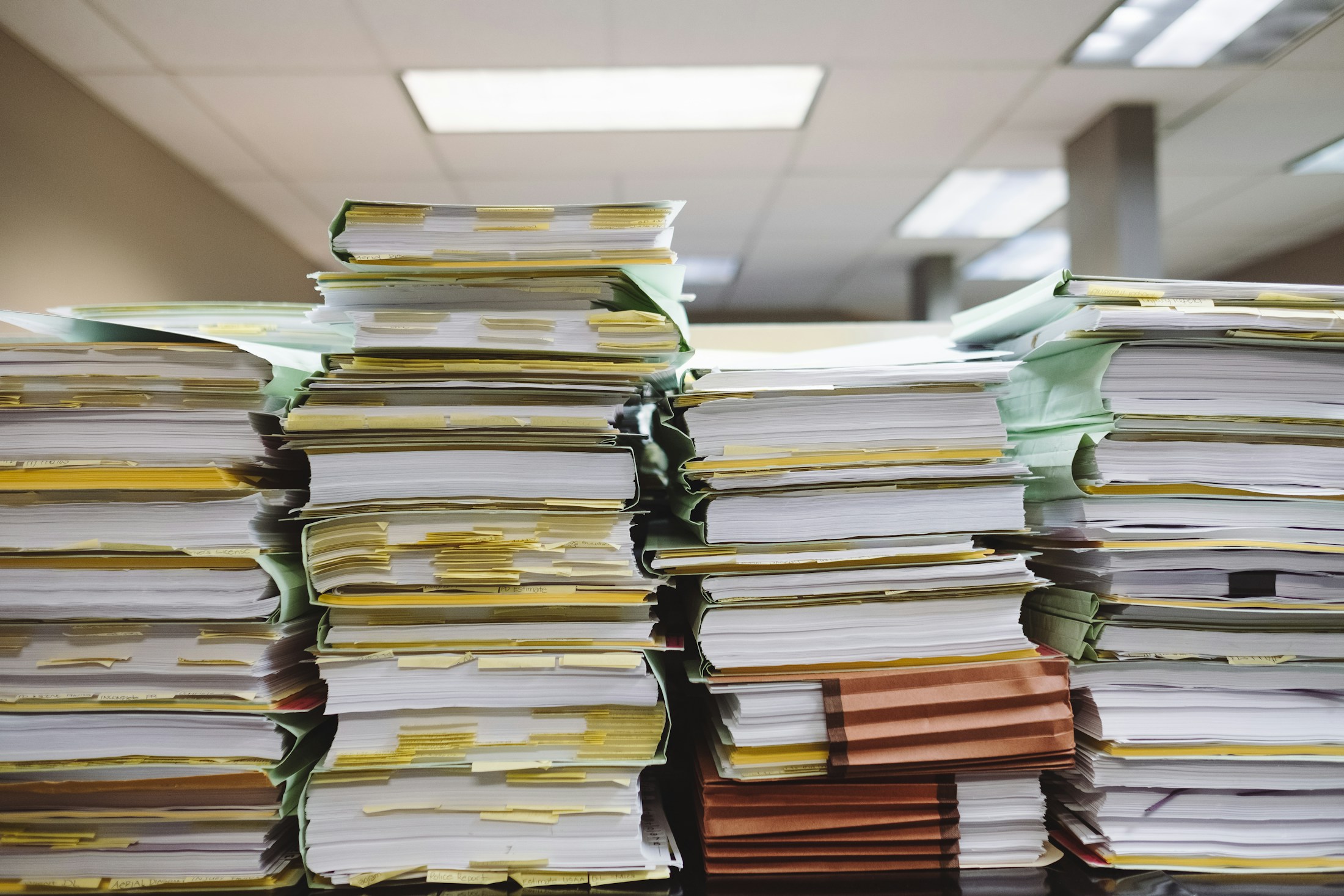 Stacks of paper records in folders.