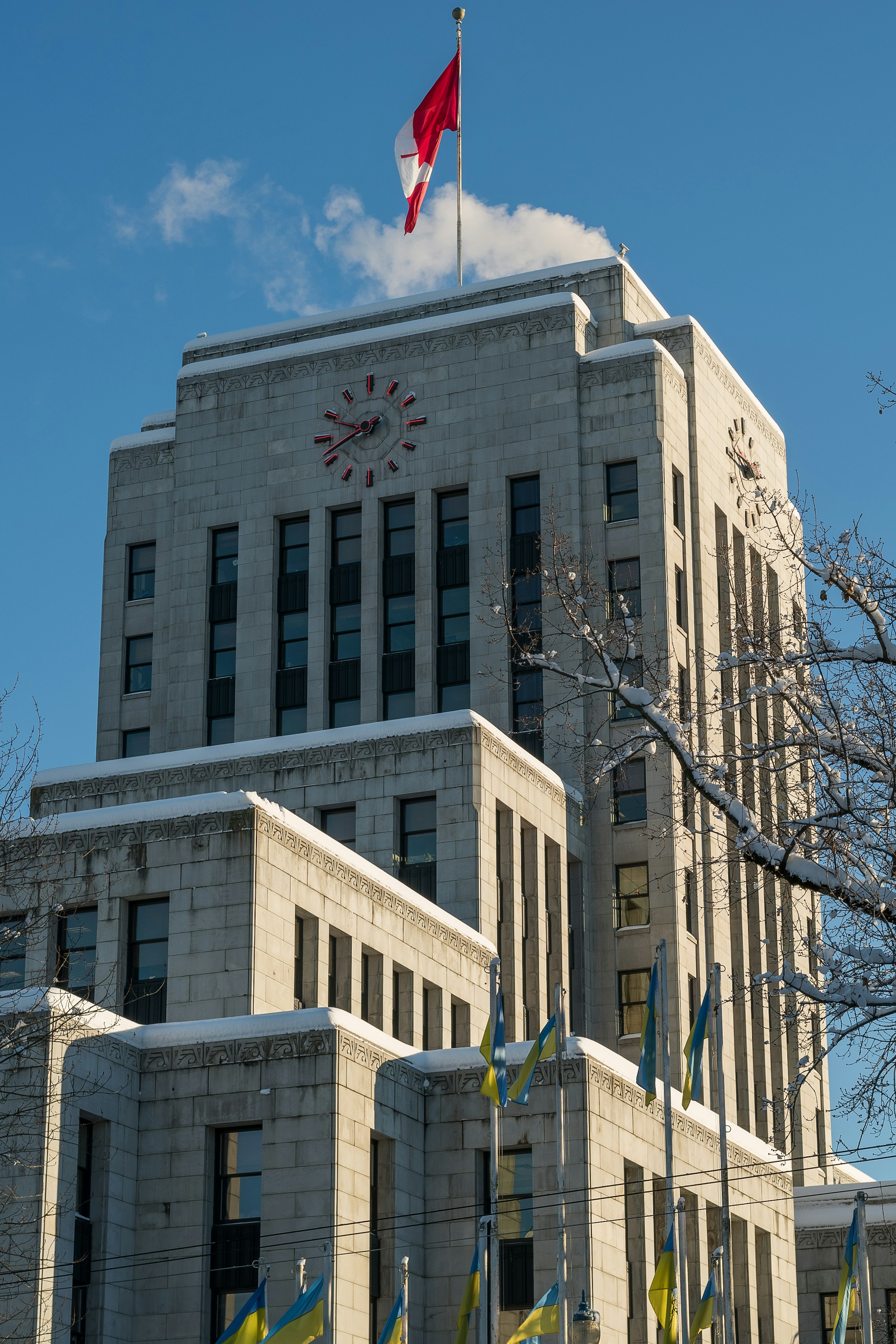 The clock and stone facade of Vancouver City Hall in winter.