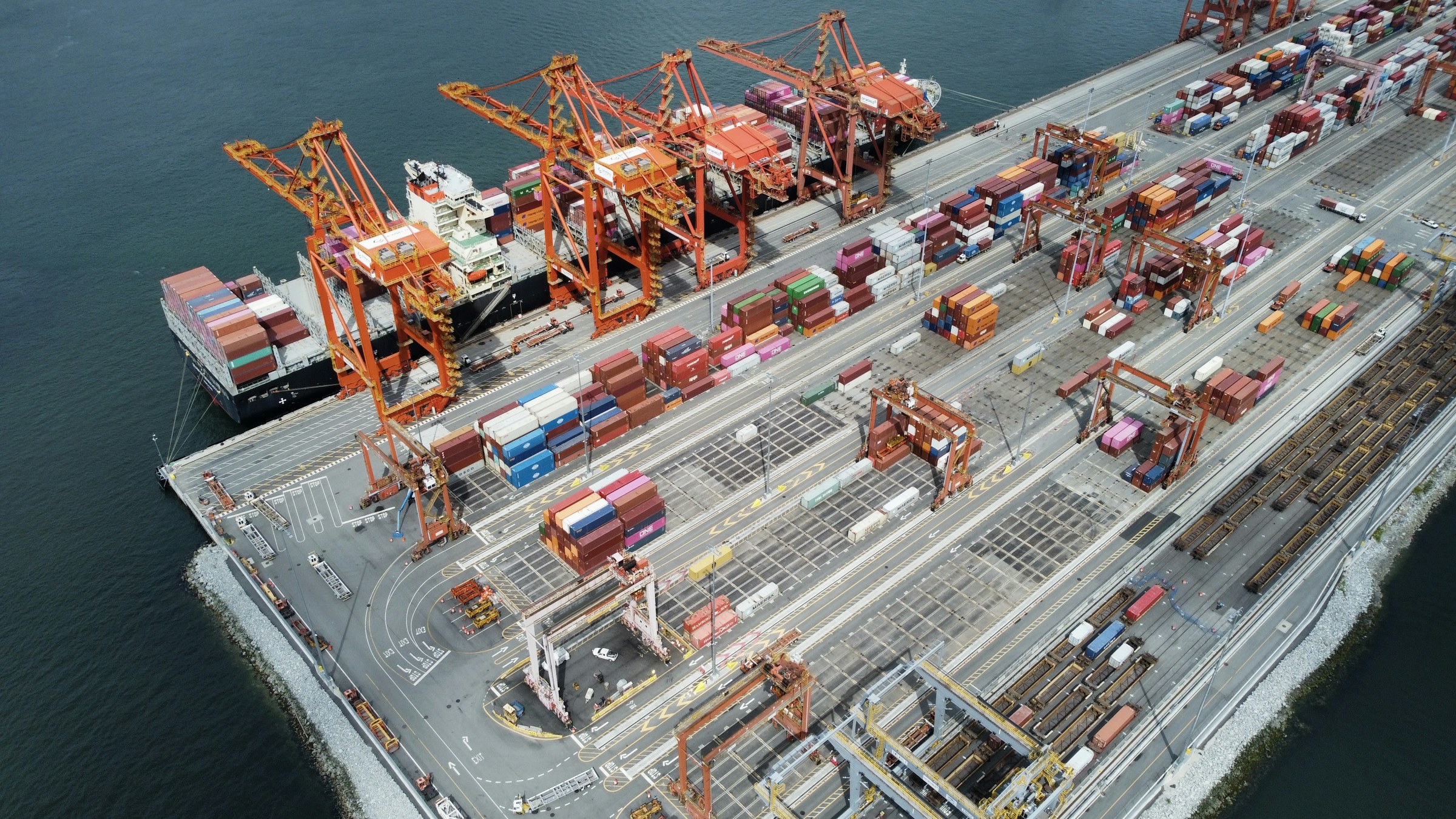 Container cranes, rail lines and a cargo ship at the Port of Vancouver.
